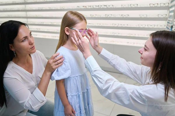 Opticien Zet Bril Meisje Gezicht Aanwezigheid Van Haar Moeder — Stockfoto