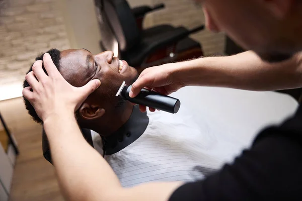 Lindo Hombre Afroamericano Encuentra Cómodamente Una Silla Peluquería Peluquero Afeita —  Fotos de Stock