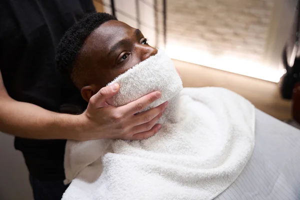 Male Barber Put Warm Towel Face African American Guy Client — Stock Photo, Image