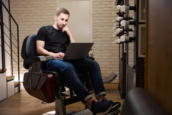 Barber Communicates Online Laptop Sitting Hairdressing Chair His Workplace Barbershop — Stock Photo, Image