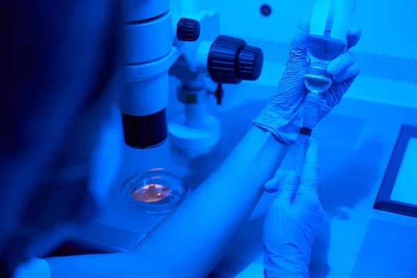 实验室职员用一个大注射器抽吸液体 在实验室里配备现代化的设备 — 图库照片