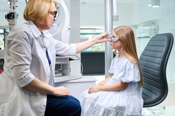 Augenoptiker Befestigt Kreuzzylinder Während Subjektiver Refraktionsprüfung Augenmusterrahmen Kindergesicht — Stockfoto