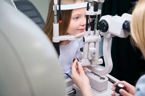 Doświadczona Okulistka Patrząca Przez Mikroskop Lampy Szczelinowej Oczy Dziewczynki — Zdjęcie stockowe