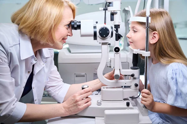 Glimlachende Vriendelijke Vrouwelijke Oogarts Onderzoeken Jonge Patiëntenogen Door Spleetlamp Microscoop — Stockfoto