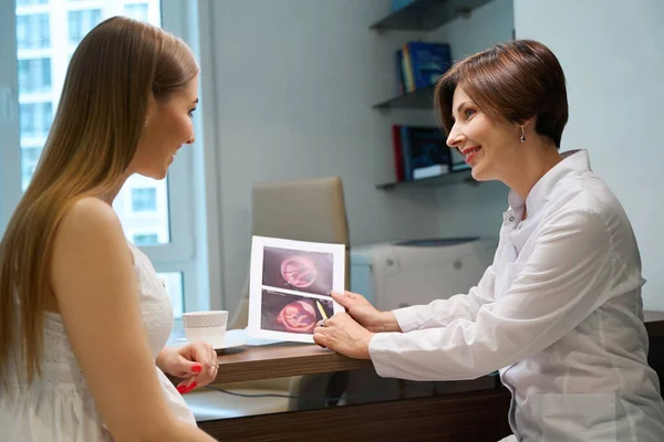 幸せな期待の母親は不妊の専門家と一緒に胎児の超音波画像を検査し 女性は暖かく伝えます — ストック写真