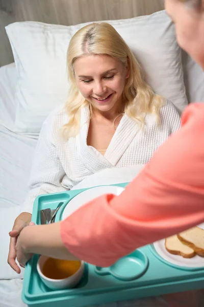 센터의 직원은 침대에서 여자를 돌보는 그녀는 그녀의 다이어트 음식을 — 스톡 사진