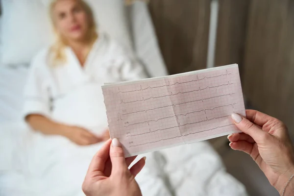 Vrouwelijke Arts Een Ziekenhuiskamer Met Elektrocardiogram Resultaten Haar Handen Een — Stockfoto