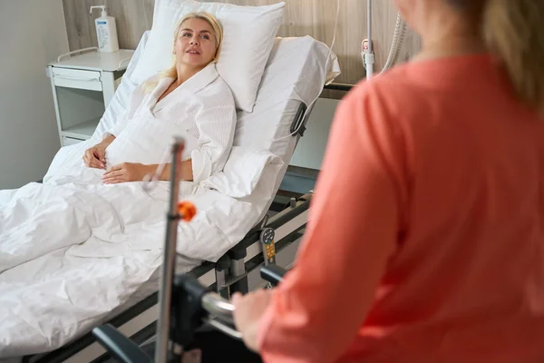 Una Mujer Con Una Bata Hospital Sienta Una Cama Especial —  Fotos de Stock