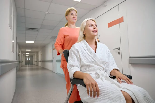 Enfermeira Cuidadora Leva Paciente Uma Cadeira Rodas Longo Corredor Hospital — Fotografia de Stock