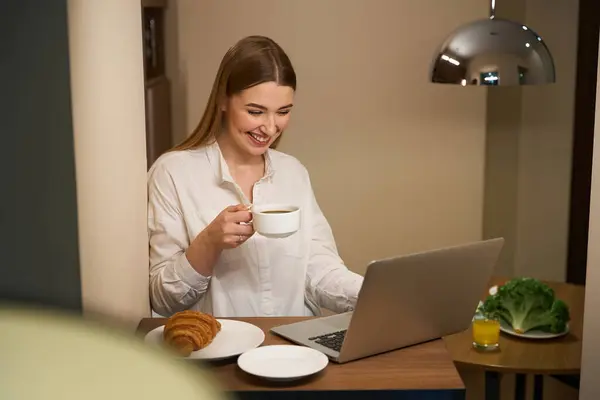 Mulher Feliz Roupas Casuais Navegando Laptop Enquanto Lanche Cozinha — Fotografia de Stock