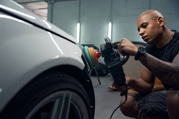 Konzentrierter Afroamerikanischer Automechaniker Poliert Autoscheinwerfer Sorgfältig Mit Spezieller Befestigung Schleifer — Stockfoto
