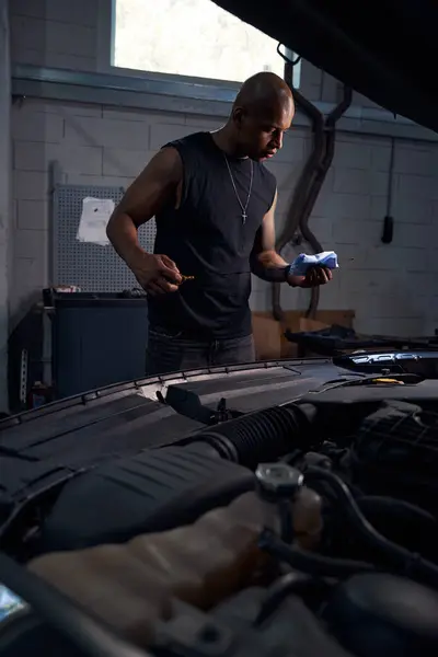 車のエンジン 自動車サービスステーションのオイル レベルを点検するラグが付いている自動車修理店の特別なゲージの良質の男性労働者 — ストック写真