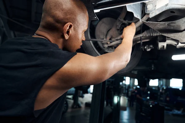 Afroamerikanischer Mechaniker Arbeitet Unter Dem Auto Mit Einem Langen Schraubenzieher — Stockfoto