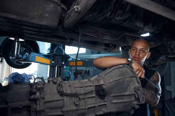 Soustředěný Afroamerický Automechanik Stojící Pod Autem Opírající Nějaké Detaily Zabývající — Stock fotografie