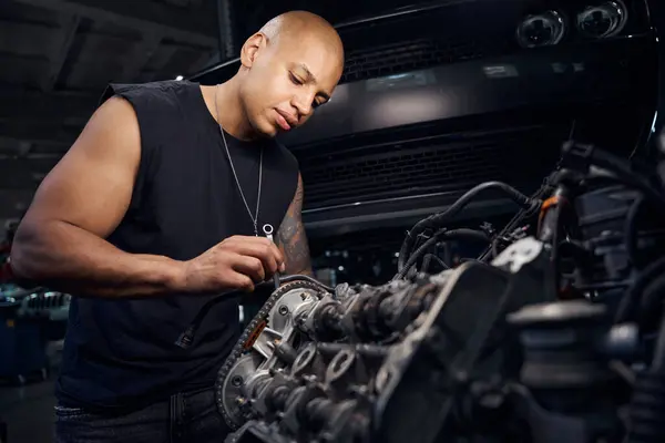 集中英俊的非洲裔美国汽车维修站工人用小扳手修理发动机的一些细节 调整和更换零件 近距离观察 — 图库照片