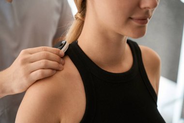 Uzman bir sağlık merkezinde donanım terapisi yapıyor, hamile bir müşteri bu işlemden zevk alıyor.