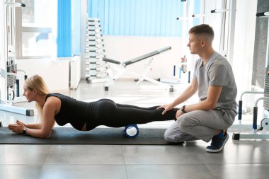 Erkek eğitmen, hamile kadınların spor salonundaki egzersizlerini yönetir. Egzersiz için özel bir cihaz kullanılır.