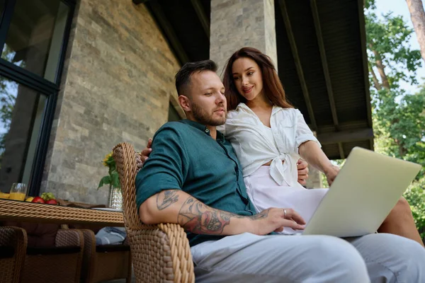 Manžel Manželka Objímají Sedí Proutěném Křesle Terase Muž Pracuje Notebooku — Stock fotografie