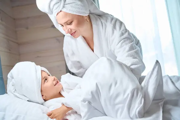 妈妈发现她漂亮的小女儿头戴大毛巾 软软的浴衣躺在毛毯下 女孩子们在一起玩 一起玩 — 图库照片