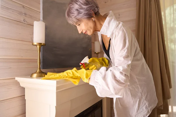 Female in casual clothes cleaning the house, woman working in protective household gloves