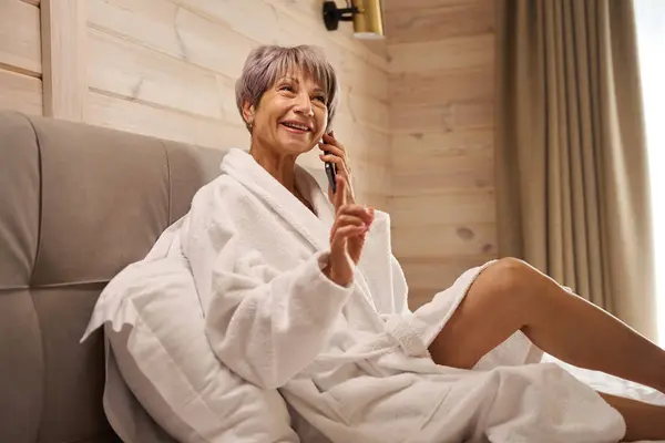 Счастливая Пенсионерка Общается Мобильному Телефону Спальне Сидит Мягких Подушках — стоковое фото