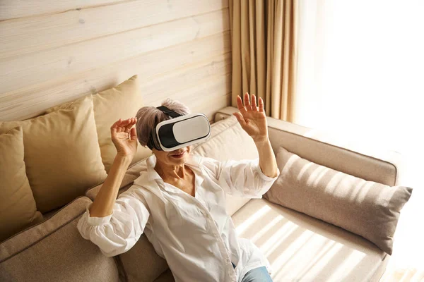 Elderly woman is passionate about a virtual game, she plays with special glasses
