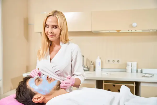 Gespecialiseerde Cosmetoloog Brengt Een Reinigingsmasker Aan Het Gezicht Van Klant — Stockfoto