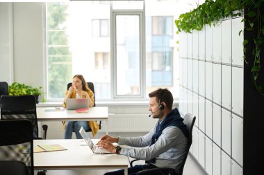 İş yerlerinde dizüstü bilgisayarları olan genç yöneticiler kulaklık kullanarak iletişim kuruyorlar. Odada büyük bir pencere var.