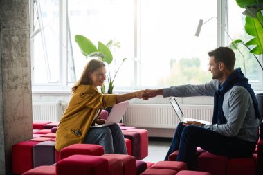 Meslektaşlar, iç mekanlarda, iç mekanlarda, ortak çalışma alanında birbirlerini selamlarlar.