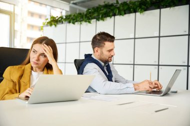 Münakaşa eden yöneticiler işyerlerinde oturuyor, insanlar büyük bir ofis masasında oturuyor.