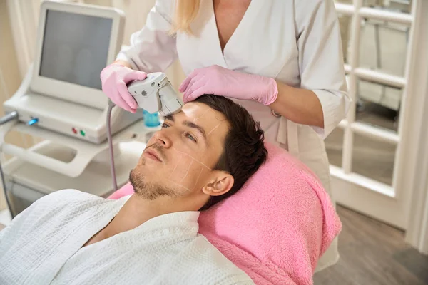 Doctor Performs Cosmetological Hardware Procedure Client Forehead Area Man Sits — Stock Photo, Image