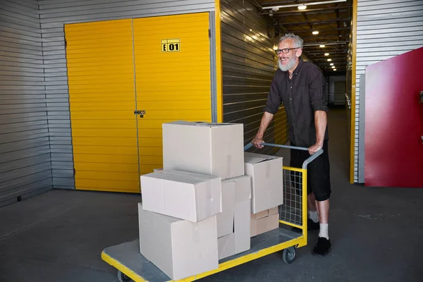 Cheerful Man Carrying Lot Boxes Cargo Cart Warehouse — Stock Photo, Image