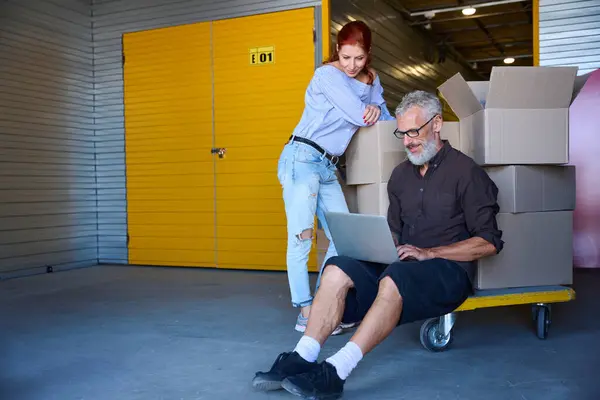 Rudowłosy Kobieta Jej Towarzysz Magazynie Ludzie Znajdują Się Laptopem Wózku — Zdjęcie stockowe
