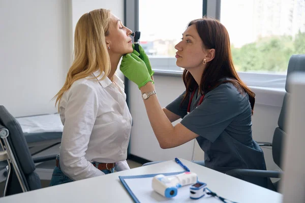 Focused Ent Physician Seated Desk Inserting Otoscope Female Patient Nostril — Stock Photo, Image