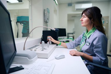 Kontrol odasındaki kumanda panelinde hareket eden odaklanmış radyografın yan görünümü