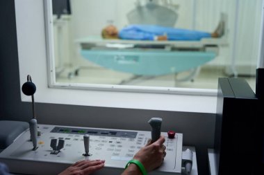 Hasta x-ray muayenesi sırasında kontrol odasındaki kumanda panelinde hareket eden radyografın kesilmiş fotoğrafı