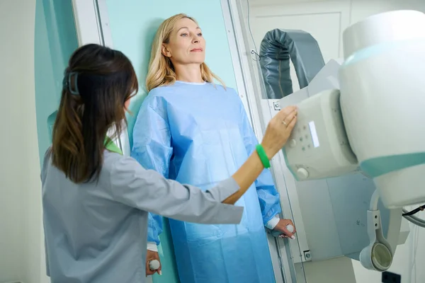 Woman Leaning Her Back Radiographic Examination Table While Radiographer Adjusting — Stock Photo, Image