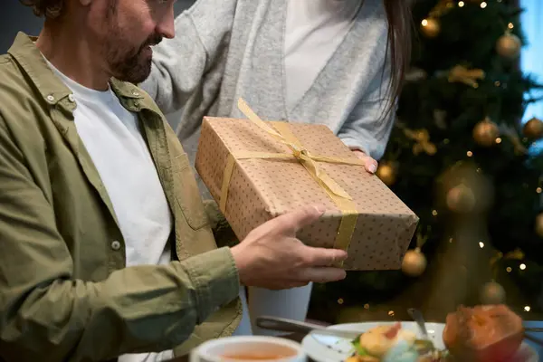 Unerkennbare Frau Überreicht Mann Geschenkbox Bei Gemeinsamer Weihnachtsfeier — Stockfoto