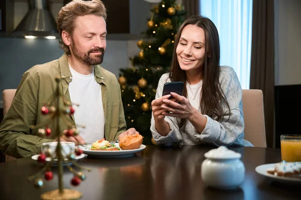 Junger Mann Frühstückt Frau Über Silvester Und Weihnachten Mit Handy — Stockfoto