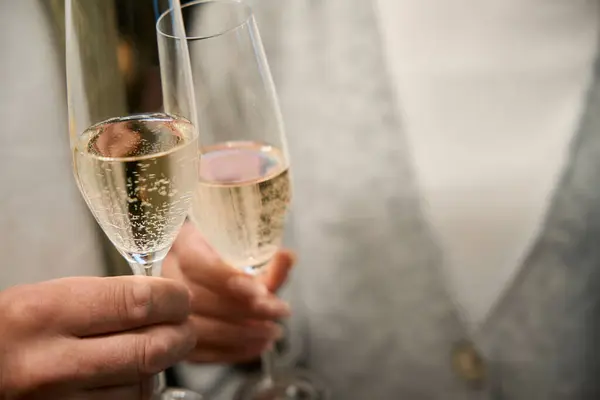 Close up of young woman and man clinking glasses with champagne during festive Christmas holidays