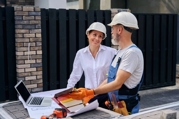 Husbyggare Som Håller Måla Prov Styrelser Framför Glada Kvinnliga Arkitektoniska — Stockfoto