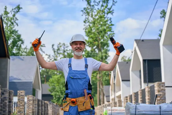Joyous Construction Worker Walkie Talkie Impact Wrench Raised Hands Standing — Stock Photo, Image