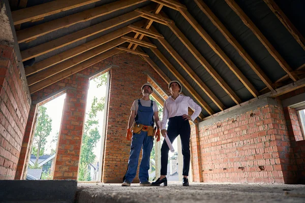 Serious Female Site Supervisor Blueprints Builder Inspecting Attic Roof Half — Stock Photo, Image