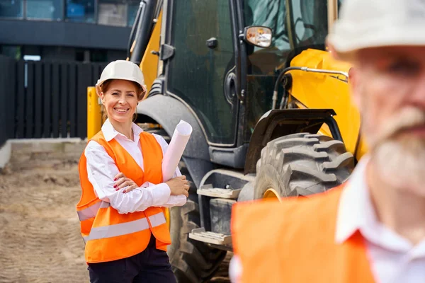 Serious Foreman Joyous Female Construction Manager Rolled Architectural Drawings Standing — Stock Photo, Image