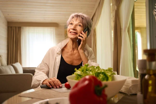Милая Пожилая Женщина Общается Мобильному Телефону Своей Кухне Готовит Овощной — стоковое фото