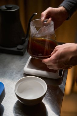 Kahve makinesinden kahve dükkanındaki cam bardağa sıcak aromatik Americano döken tanınmamış barista.