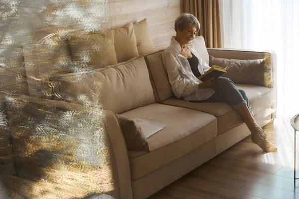 Smiling Elderly Lady Relaxing Book Cozy Sofa Next Computer Work — Stock Photo, Image