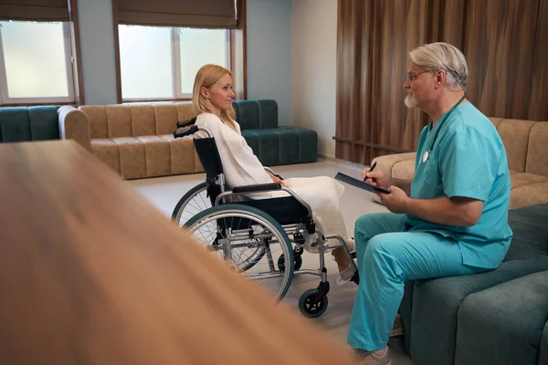 Clinician Taking Notes Clipboard While Looking Hospitalized Woman Seated Wheelchair — Stock Photo, Image
