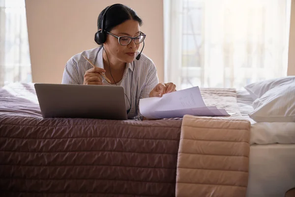 Focused Businesswoman Headset Lying Bed Suite Front Portable Computer Looking — Stock Photo, Image