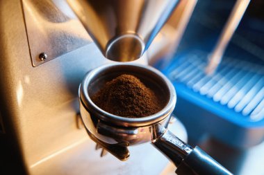 Kahve öğütücüsü taze kavrulmuş fasulyeyi toza çevirir.